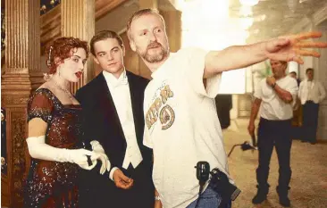  ??  ?? Director James Cameron (right) on the set with lead stars Kate Winslet and Leonardo DiCaprio.