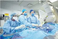  ??  ?? Dr. Annapoorna Kini, centre, performs a non-emergency angioplast­y at Mount Sinai Hospital in New York. Through a blood vessel in the groin, she guides a tube to a blockage in the heart. She inflates a tiny balloon to flatten the clog, and leaves behind...