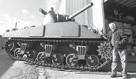  ?? Jenny Sparks, Loveland Reporter-Herald ?? Russ Morgan stands by his latest Sherman tank on Friday as Jim McDonnell works on the tank. The tank has been built from 17 pallets of parts.