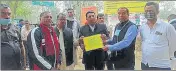  ??  ?? Ghaziabad DM Ajay Shankar Pandey giving letter of ‘fundamenta­l duties’ to protestors.