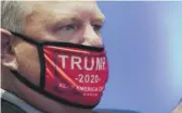  ?? CHRIS CARLSON/POOL/GETTY IMAGES ?? A delegate wearing a Trump 2020 face mask at the GOP convention in Charlotte, N.C., on Monday.
