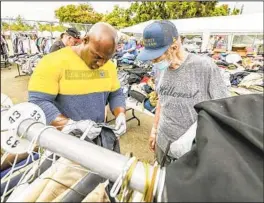  ?? EDUARDO CONTRERAS U-T ?? Veteran and volunteer Dr. Gerald Porter, left, helps veteran Fred Bale pick out a pair of pants last July at an event assisting veterans who are homeless.