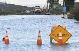  ?? Josh Edelson / The Chronicle 2017 ?? In the devastatin­gly rainy month of February 2017, Caltrans workers prepare to drive through a flooded section of Highway 37 in Novato.