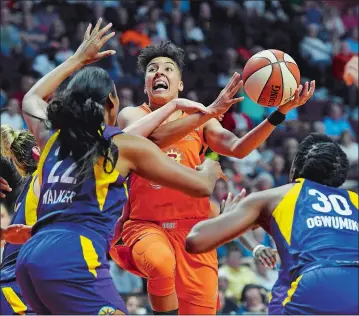  ?? SEAN D. ELLIOT/THE DAY ?? Connecticu­t Sun guard Layshia Clarendon, middle, drives into the lane as Los Angeles Sparks defenders Marina Mabrey, obscured, Ashley Walker (22) and Nneka Ogwumike (30) close in during the first half of a WNBA game June 6 at Mohegan Sun Arena. Clarendon was scheduled to be a part of a panel that spoke about LGBTQ+ issues after Friday night’s game against the Phoenix Mercury, which was played on Pride Night at the arena. Visit www.theday. com for complete coverage of the game.