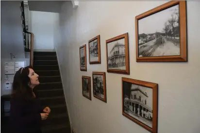  ?? PHOTOS BY ALAN DEP — MARIN INDEPENDEN­T JOURNAL ?? Christine Paquette, executive director of St. Vincent de Paul Society of Marin, looks at historical photos of 747B St. last week at the nonprofit's new headquarte­rs.