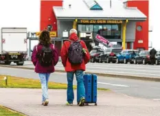  ?? Foto: Frank Molter/dpa ?? Diese beiden Urlauber sind auf dem Weg zur Fähre in Dagebüll. An der Nordsee darf man jetzt wieder Urlaub machen – und bald dürfen wir auch wieder ins benachbart­e Ausland reisen.