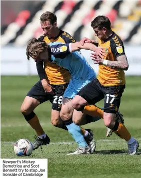  ??  ?? Newport’s Mickey Demetriou and Scot Bennett try to stop Joe Ironside of Cambridge