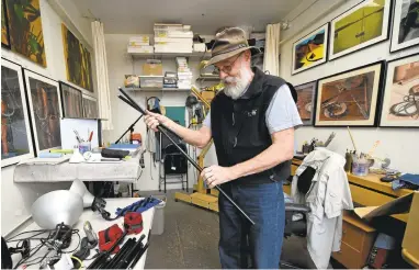  ?? JOSE CARLOS FAJARDO/STAFF PHOTOS ?? Artist John Warhus, 70, of Richmond, begins to dismantle light stands in his studio at Bridge Storage and Art Space on Friday in Richmond. Warhus pays $405 per month for the 150-square-foot space that he has occupied since 2013.