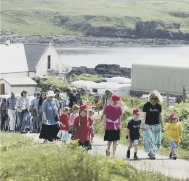  ?? PICTURE: JANE BARLOW ?? 0
Residents of Eigg celebrate the tenth anniversar­y of its community buyout