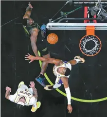  ?? AP-Yonhap ?? New Orleans Pelicans forward Zion Williamson, top, goes to the basket against Los Angeles Lakers forward Rui Hachimura, right, and forward Anthony Davis during the first half of an NBA basketball game in New Orleans, Sunday.