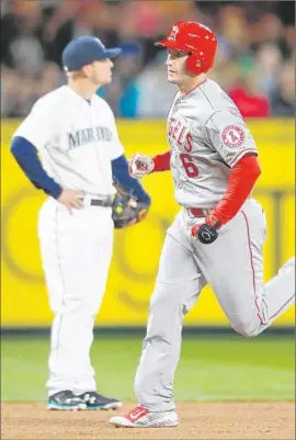  ?? Otto Greule Jr. Getty Images ?? DAVID FREESE runs past Seattle Mariners third baseman Kyle Seager after hitting a two-run home run in the fourth inning in the Angels’ 2-0 victory.