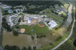  ?? MICHAEL CLEVENGER — COURIER JOURNAL VIA AP ?? River remians high around a grouping of homes in Breathitt County, Ky., on Saturday. Kentucky Gov. Andy Beshear said the death toll from flooding rose to 28 on Sunday.