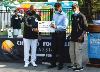  ?? TYLER LARIVIERE/SUN-TIMES ?? Steven B. Clay, a student at Lindblom Academy, accepts his scholarshi­p Thursday from organizers during the Chicago Football Classic at the DuSable Museum of African American History.