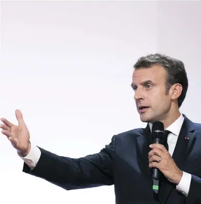  ?? IAN LANGSDON / AFP / GETTY IMAGES ?? French President Emmanuel Macron, who presents well and moves about the internatio­nal stage with ease, has been tinged in recent days by a series of videos depicting his bodyguard’s brutal manhandlin­g of May Day protesters.