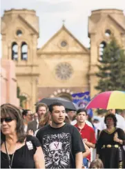  ??  ?? Andrew Romero, center, participat­es Sunday in the annual Fiesta de Santa Fe procession. In 1997, Romero’s father was fatally shot during a Fiesta celebratio­n.