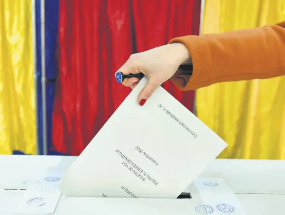  ?? ?? A woman casts her vote in Romania’s legislativ­e election, Bucharest, Romania, Dec. 6, 2020.