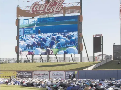  ?? JANE THERESE/SPECIAL TO THE MORNING CALL ?? Imam Basheer Bial, of the Whitehall Muslim Associatio­n of the Lehigh Valley, leads the crowd in prayer Sunday morning during the first time Lehigh Valley Muslims gathered in Coca-Cola Park in Allentown to celebrate one of the biggest holy days on the Islamic calendar.