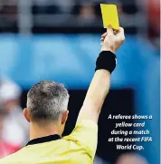  ??  ?? A referee shows a yellow card during a match at the recent FIFA World Cup.