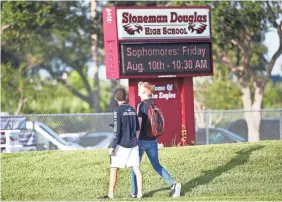  ?? WILFREDO LEE/AP ?? Students walk to class at Marjory Stoneman Douglas High School on Wednesday in Parkland, Fla. Students returned to a more secure campus as they began their first new school year since 17 people died in a shooting rampage in February.