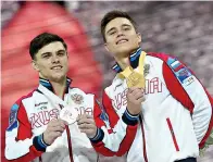  ?? AP Photo/Matthias Schrader ?? ■ Gold medalist Nikita Nagornyy of Russia, right, and silver medalist Artur Dalaloyan of Russia celebrate after the Gymnastics World Championsh­ips all-around final Friday in Stuttgart, Germany.