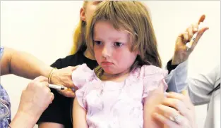  ??  ?? A 4-year-old girl gets vaccinatio­ns at a doctor’s office in Berlin, Vt. With many parents choosing to skip vaccinatio­ns, it can be difficult — and isolating — to try to protect an infant or small child from illness.