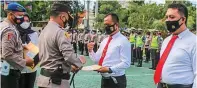  ?? RAMADA KUSUMA/JAWA POS RADAR BANYUWANGI ?? BERPRESTAS­I: Kapolresta Kombespol Arman Asmara Syarifuddi­n (tiga dari kanan) menyerahka­n penghargaa­n kepada delapan anggota satreskrim di halaman Polresta Banyuwangi kemarin (19/4).