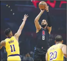  ?? Associated Press ?? Los Angeles Clippers forward Marcus Morris Sr. (8) shoots as Los Angeles Lakers guard Malik Monk (11) and guard Avery Bradley (20) defend during the first half of the Hallway Series on Thursday in Los Angeles. Morris scored 29 points to help lead the Clippers in a 111110 victory.