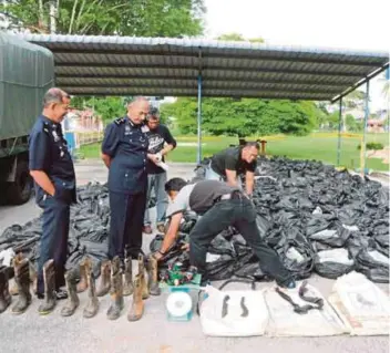  ??  ?? MIOR Farid Alatrash (dua dari kiri) melihat bungkusan daun ketum dan barangan yang dirampas dalam serbuan di dua blok rumah ladang di Kampung Lamdin, Naka, kelmarin.