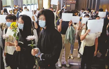  ?? REUTERS ?? Gente con hojas blancas recordaron a las víctimas de un incendio en Urumqi, en Hong Kong