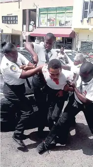  ?? CONTRIBUTE­D ?? Security guards tackle a fleeing alleged robber in a plaza along Constant Spring Road.