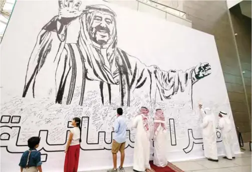  ?? — Photo by Yasser Al-Zayyat ?? KUWAIT: Kuwaitis write remarks on a banner bearing the image of their Amir HH Sheikh Sabah Al-Ahmad Al-Jaber Al-Sabah, at the Avenues Mall in Kuwait City yesterday, on the third anniversar­y of the United Nations honoring him as a humanitari­an leader.