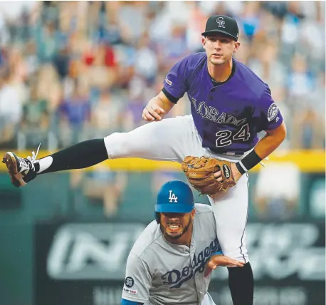  ?? David Zalubowski, The Associated Press ?? Rockies second baseman Ryan McMahon jumps over the Los Angeles Dodgers’ Edwin Rios after forcing him out at second base on the front end of a double play during the second inning Sunday at Coors Field.