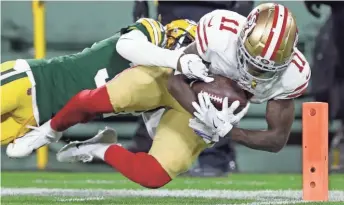  ?? DAN POWERS / USA TODAY NETWORK-WISCONSIN ?? 49ers receiver Marquise Goodwin dives into the end zone in front of Packers cornerback Tramon Williams.