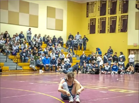  ?? Alexandra Wimley/Post-Gazette ?? Burrell’s Stevie Hasson sits alone on the mat after losing the final match to Quaker Valley’s Justin Richey in the WPIAL Class 2A championsh­ip Saturday at Chartiers- Houston. The Quakers’ 30-28 decision ended Burrell’s 15-year championsh­ip reign.