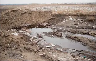  ??  ?? CHINA: This picture shows an area strewn with rubbish and cow manure in front of a dairy farm (in background) in Gannan county, Heilongjia­ng province.