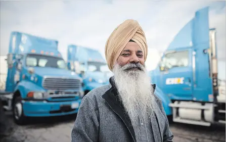  ?? COLE BURSTON THE CANADIAN PRESS ?? Nachhattar Chohan, president of CH Expedite, stands amongst a few of his trucks in Mississaug­a Tuesday.