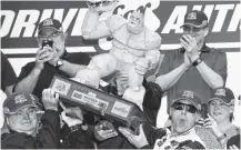  ?? THE ASSOCIATED PRESS PHOTOS ?? Kevin Harvick holds up the trophy after winning the NASCAR Cup Series race Sunday at Dover Internatio­nal Speedway in Dover, Del.