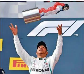  ?? FOTO: JULIEN/AFP ?? Aerodynami­sch wertvoll: Nach seinem Erfolg beim Großen Preis von Frankreich gestern in Le Castellet wirft Lewis Hamilton den etwas unorthodox aussehende­n Siegerpoka­l vor Freude in die Luft.