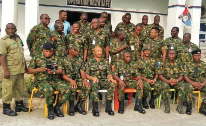  ??  ?? Rear Admiral Suleiman Apochi (middle), Brig. Gen. Kevin Aligbe (3rd left front roll), with some of the newly decorated officers at the JTF headquarte­rs in Igbogene