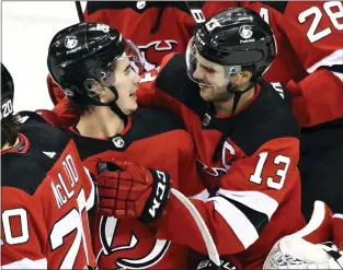  ?? BILL KOSTROUN — THE ASSOCIATED PRESS ?? Devils’ Jack Hughes celebrates with Nico Hischier (13) after Hughes scored the winning goal during the overtime period on Friday against the Oilers.