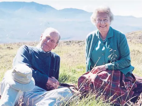  ??  ?? The Queen has shared one of her favourite pictures of herself with the Duke of Edinburgh on the eve of her husband’s funeral. The royal couple are pictured as they are rarely seen – relaxing together away from public duties and enjoying the stunning scenery of the Highlands at a beauty spot near Ballater.