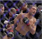  ?? GREGORY PAYAN — THE ASSOCIATED PRESS ?? Brian Ortega grabs his injured shoulder as doctors tend to him after his fight against Yair Rodriguez on Saturday.