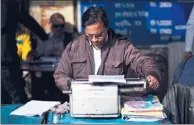  ?? BERNAT ARMANGUE / ASSOCIATED PRESS ?? A roadside typist works near the stock exchange in New Delhi, India, one of the last countries where the typewriter remains a part of everyday life.