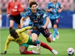  ?? — AFP ?? Falling over: Japan forward Yuya Osako (front) tumbles after being tripped by Cameroon’s Jean Onana.