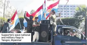  ??  ?? Supporters wave national and military flags in Yangon, Myanmar