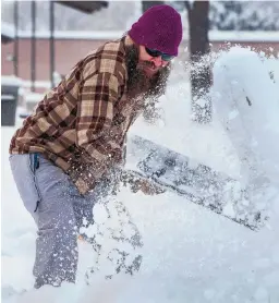  ?? EDDIE MOORE/JOURNAL ?? Chip Miller, with the city of Santa Fe’s Parks and Recreation Department, shovels several inches of snow off a sidewalk in front of the Salvador Perez Recreation­al Park in Santa Fe.