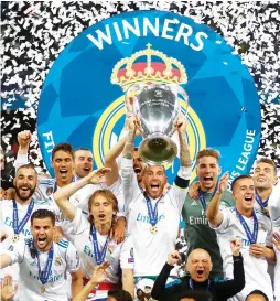  ?? (Reuters) ?? REAL MADRID celebrates winning the Champions League for a third year in a row after its 3-1 victory over Liverpool in Saturday night’s final in Kiev.