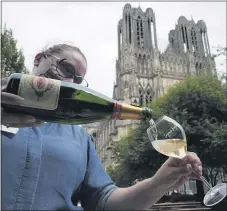  ?? (AP PHOTO/FRANCOIS MORI) ?? A waitress serves a glass of champagne at La Grande Georgette restaurant in front of the cathedral in Reims, the Champagne region, east of Paris, Tuesday, July 28, 2020.