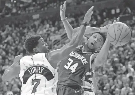  ?? AP ?? Toronto guard Kyle Lowry and Milwaukee Bucks star Giannis Antetokoun­mpo battle for a loose ball during the first half.