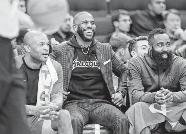  ?? Elizabeth Conley / Staff photograph­er ?? Injured guard Chris Paul, center, seems to be enjoying himself as he watches the team’s win Monday night. Paul had one of the best seats in the house, between P.J. Tucker, left, and James Harden.